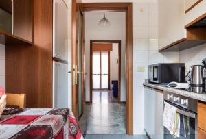 een hal die leidt naar een keuken met een magnetron bij Parma A due passi dall'Ospedale Apartment in Parma