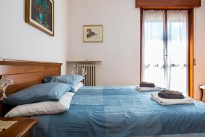 een slaapkamer met een blauw bed en handdoeken bij Parma A due passi dall'Ospedale Apartment in Parma