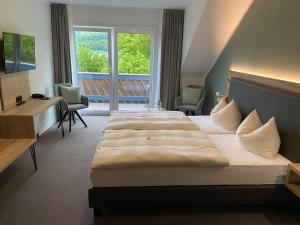 a hotel room with two beds and a window at Hotel & Restaurant Kronenhof am Weser-Radweg in Oedelsheim