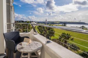 a balcony with a table and chairs and a view of the ocean at 1 Elliot Terrace in Plymouth