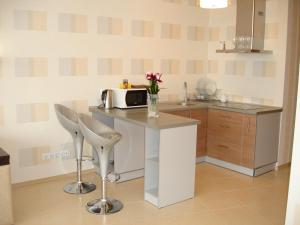 cocina con encimera, microondas y sillas en Most City Premium apartments, en Dnipro