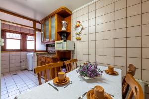 uma cozinha com uma mesa com flores em Aconchegante Apartamento no Centro de Gramado em Gramado