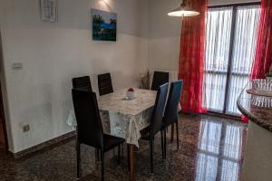 a dining room with a table with black chairs and a tableablish at Apartment Licardo in Sveti Lovreč Pazenatički