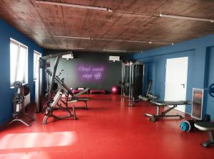 a gym with cardio equipment in a room with blue walls at Salsa Hostel Premium in Łódź