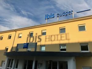 een geel gebouw met een bord erop bij ibis budget Haguenau Strasbourg Nord in Haguenau