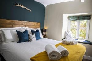 een slaapkamer met een groot bed en handdoeken bij Church House Inn, Churchstow in Kingsbridge
