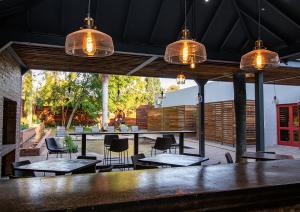 a patio with tables and chairs and pendant lights at The Doors Inn in Mokopane