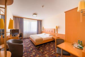 ワルシャワにあるホテル パートナーのベッドとテレビが備わるホテルルームです。