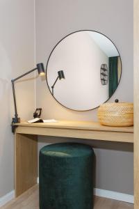 a desk with a round mirror and a green stool at BJØRVIKA APARTMENTS, Teaterplassen, Oslo city center in Oslo