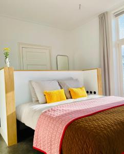 a bedroom with a large bed with yellow pillows at Villa Wanrooy in Doetinchem