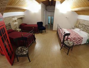 a bedroom with two beds and a couch and chairs at Residenza delle Grazie in Miglionico