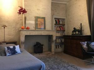 a bedroom with a fireplace and a bed and a chair at Côté-Serein suites familiales du Clos in Noyers