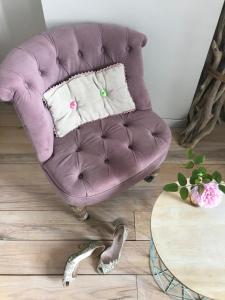 Coursan的住宿－Le logis blanc bed&breakfast，客厅配有一张桌子,配有一张紫色椅子