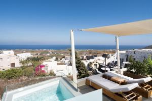 a villa with a swimming pool and a view of the ocean at Edem Luxury Hotel in Oia