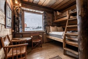 a bedroom with a bunk bed and a desk and a window at Basecamp Hotel in Longyearbyen