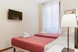 Borgo Pinti Cozy Flat في فلورنسا: غرفة فندقية بسريرين وتلفزيون بشاشة مسطحة