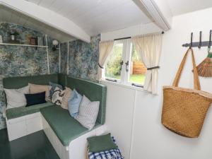 a room with a green couch and a window at Hazel Nook in Narberth