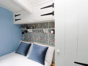 a bedroom with a bed with blue and white pillows at Hazel Nook in Narberth