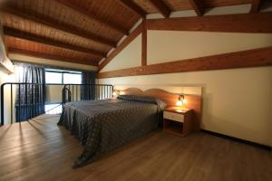 ヴァレッジョ・スル・ミンチョにあるHotel Edenの木製の天井の客室で、ベッドルーム1室(ベッド1台付)