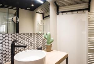 baño con lavabo blanco y cactus en So Sweet Capitole en Toulouse