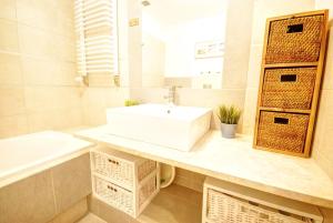 een badkamer met een witte wastafel, een bad en een wastafel bij HelApart - Helska Villa in Hel +43 foto's