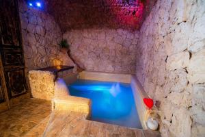 a bath tub in a stone room with a blue pool at B&B La Sorgente in Brindisi +33 photos