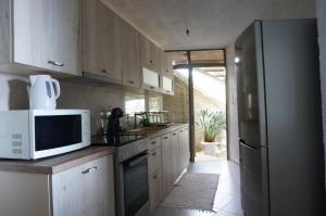 a kitchen with a white microwave and a refrigerator at Kefalonia Sea View Cottage in Áno Váltai