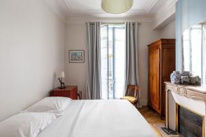 En eller flere senge i et værelse på Veeve - Elegant Interiors in Bastille