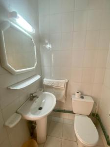 a white bathroom with a toilet and a sink at Le Lagon Bleu Oualidia in Oualidia