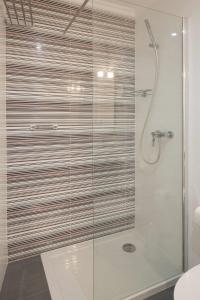 uma casa de banho com um chuveiro e uma porta de vidro em Central Gold Studio em Lisboa