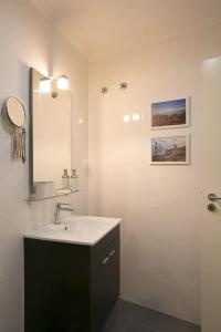uma casa de banho com um lavatório e um espelho em Central Gold Studio em Lisboa