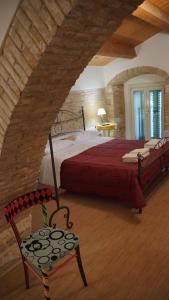 a bedroom with a red bed and a chair at Residenza delle Grazie in Miglionico