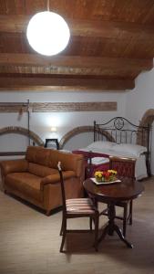 a living room with a couch and a table and a bed at Residenza delle Grazie in Miglionico