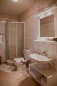 a white toilet sitting next to a bath tub in a bathroom at Hotel Splavar in Brežice