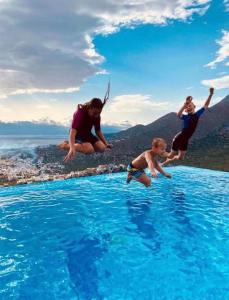 a group of people jumping into a swimming pool at Villa Estée, luxury villa with private infinity pool and jacuzzi in Elounda