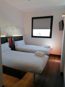 a hotel room with a bed and two lamps at easyHotel Malaga City Centre in Málaga