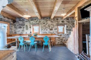 ein Esszimmer mit einem Holztisch und Stühlen in der Unterkunft Baita dai Cotai in Groppe de Fora