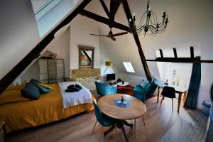 La Vallée du Launay في Taden: غرفة نوم بسرير وطاولة وكراسي
