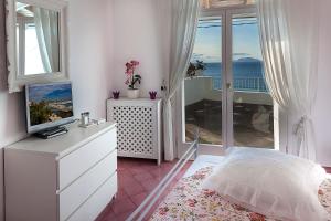 Schlafzimmer mit einem Bett, einem TV und einem Balkon in der Unterkunft La Villa Resort & Spa in Ischia