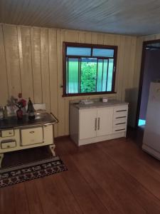 a kitchen with a sink and a window in a room at Casa chácara in Cará-Cará