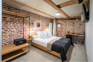 a bedroom with a bed and a brick wall at Rixwell Old Riga Palace Hotel in Rīga
