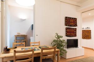 a dining room with a table and a tv at Dimora Certosa - Milano in Milan