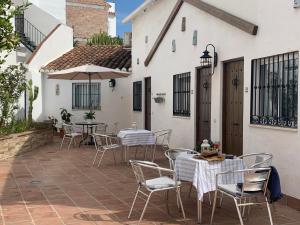 a patio with tables and chairs in a courtyard at Apartamentos Nerjaluna in Nerja