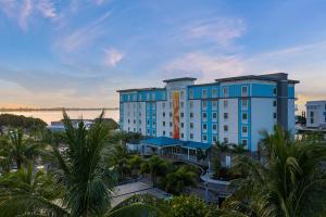 a large blue building with palm trees in front of it at Compass Hotel by Margaritaville Anna Maria Sound in Bradenton