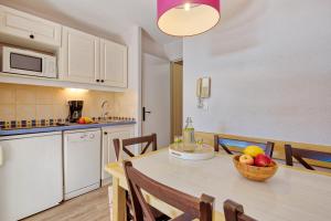 une cuisine avec une table avec un bol de fruits dessus dans l'établissement Résidence Pierre & Vacances La Pinède, à Hyères