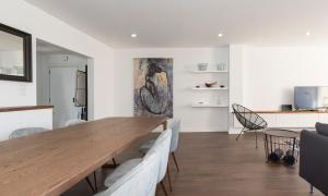 a dining room with a wooden table and chairs at HOUZE_Lovely flat with swimming pool! in Cascais