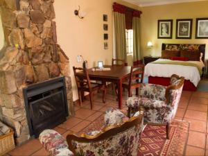 ein Wohnzimmer mit Steinkamin und ein Schlafzimmer in der Unterkunft Jocks Cottages in Dullstroom