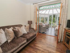 a living room with a couch and a sliding glass door at Red Squirrel Cottage, 5 Biddlestone in Morpeth