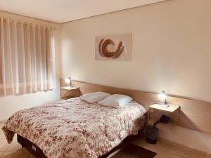 1 dormitorio con 1 cama y 2 luces en 2 mesas en Agata Hotel en Soledade