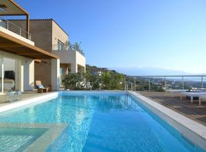 a large blue swimming pool next to a building at Deluxe Crete Villa Villa Apoi 4 bedroom villa Private Pool Sea Views Chania in Chania